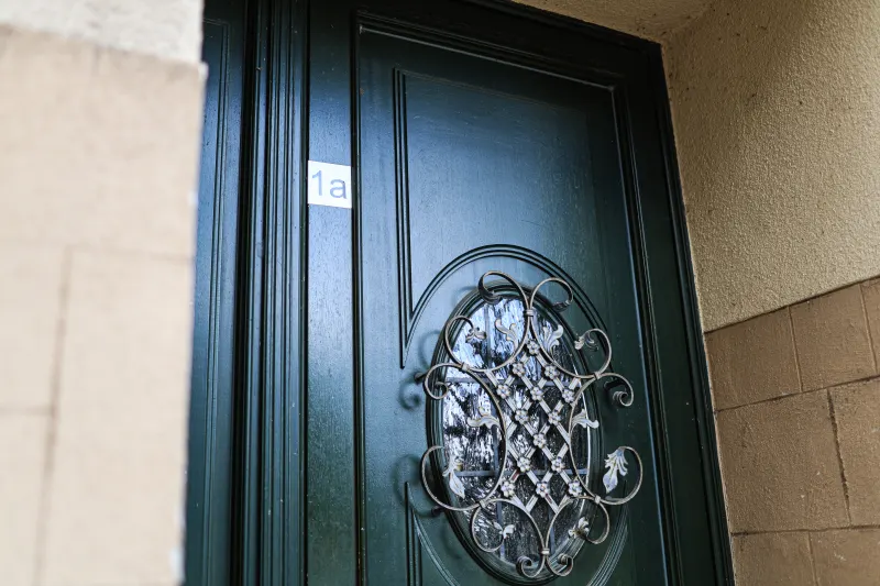 Dunkelgrüne Haustür der Hausnummer 1a mit schmiedeeisernem Jugendstil-Gitter