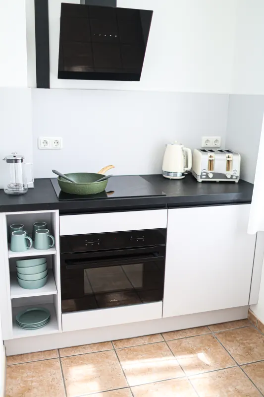 Küchenzeile mit Induktionskochfeld, Backofen, Dunstabzug, Wasserkocher und Toaster